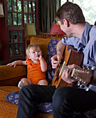 Caucasian father playing guitar for daughter, Los Angeles, California, USA