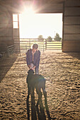Mixed race girl feeding calf in barn, Nampa, Idaho, USA