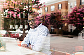 Black man using laptop in coffee shop, Norfolk, Virginia, USA