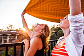 Caucasian teenage girls holding blanket on bridge, Folsom, California, United States