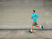 Caucasian man running on city street, Los Angeles, California, USA