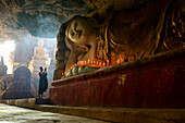 Asian monk lighting incense in temple, Hpa-An, Kayin, Myanmar