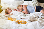 Caucasian girl and toddler brother asleep on bed, Santa Fe, New Mexico, USA