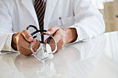 Close up of mixed race doctor holding stethoscope, C1