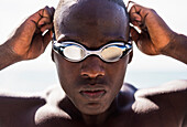 Mixed race swimmer putting on goggles, C1