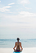 Kaukasische Frau meditiert am Strand, Jupiter, Florida, USA