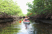 Mixed race woman kayaking in river, Miami, Florida, United States