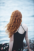 Rear view of girl sitting on beach, Bainbridge Island, WA, USA