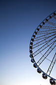 Low angle view of ferris wheel against blue sky, Seattle, Washington, United States