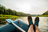 Man resting feet on boat in lake, Ykaterinburg, Swerdlowsk, Russia