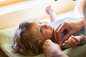 Mother dressing baby boy on changing table, Santa Fe, New Mexico, USA