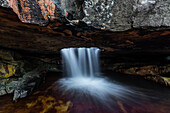 Time lapse view of waterfall flowing in rock cave, Gifberg Holiday Farm, Northern Cape, South Africa