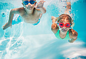 Caucasian children swimming underwater in pool, Huntington Station, New York, USA