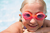 Caucasian girl wearing goggles in swimming pool, Huntington Station, New York, USA