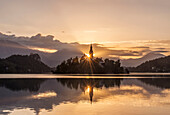 Sunrise over church tower reflected in still lake, Bled, Upper Carniola, Slovenia, Bled, Upper Carniola, Slovenia