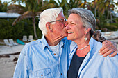 Caucasian man kissing wife on beach, Florida Keys, Florida, USA