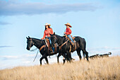 Caucasian mother and son riding horses in grassy field, Joseph , Oregon, USA
