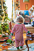 Caucasian baby boy playing with toys near Christmas tree, C1