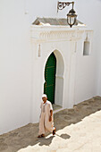Morocco, Asilah, man walking in medina street
