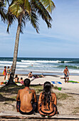 Brazil, Bahia state, Itacaré, couple sitting on the beach