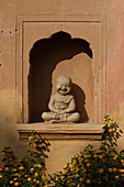 India, Rajasthan, a statue of a smiling buddha in a garden