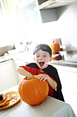 A boy preparing a Halloween pumpkin, it is disguised as Zorro
