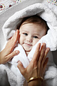 Porträt eines 4 Monate alten Babys nackt in einem Handtuch