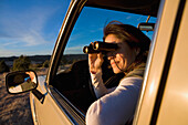 Hispanic woman looking through binoculars
