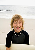 Boy holding surfboard at beach