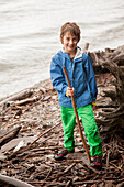 Caucasian boy playing with sticks by river