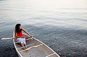 Caucasian woman sitting in canoe in lake