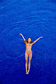 Caucasian woman floating in swimming pool