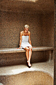 Caucasian woman relaxing in sauna