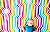 Baby Laying on Colorful Geometric Fabric, High Angle View