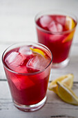 Two Glasses of Cranberry Juice with Ice and Lemon