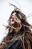 Young Woman with Wind Blowing Hair in Face, Low Angle View