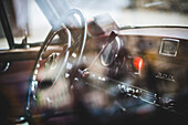 Steering Wheel and Dashboard of Vintage Mercedes Through Window and Reflections