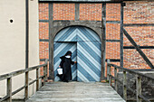Benedictine nun at gate, Abbey at Burg Dinklage, Lower Saxony, Germany