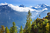 A female hiker is jumping in the air near Embd, in the Mattertal in Swiss Alps. This region of Wallis, close to Zermatt, is famous for the outdoor activities one can do. It is a paradise for hikers, climbers, mountainbikers and nature lovers. In the backg