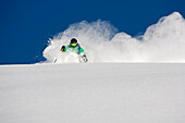 A man skiing powder on a beautiful sunny day in Utah.