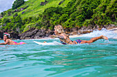 Surfer girls in ocean water.