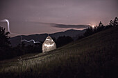 Painting with light on a haystack. Hay is on a slope with mountain Radocelo in the background.