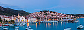 Elevated view over the picturesque harbour town of Hvar illuminated at dusk, Hvar, Dalmatia, Croatia, Europe