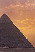 The sun setting behind the Pyramid of Khafre in Giza, UNESCO World Heritage Site, near Cairo, Egypt, North Africa, Africa