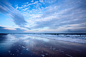 Cloud reflections at twilight on Alnmouth Beach, Northumberland, England, United Kingdom, Europe