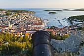 Hvar Fortress cannon and Hvar Town at sunset taken from the Spanish Fort (Fortica), Hvar Island, Dalmatian Coast, Adriatic, Croatia, Europe