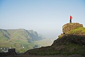 Hiker above coastal scenery, Vik, Iceland, Polar Regions