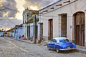 Cobbled street at sunset with classic American car, Trinidad, Cuba, West Indies, Central America