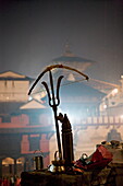 A holy man's bow placed on a bronze sculpture of a Shiva trident, Hindu festival of Shivaratri, Pashupatinath, Kathmandu, Nepal, Asia