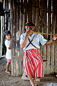 An Achuar man plays an Achuar flute, Amazon, Ecuador, South America